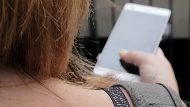 Woman back while typing on her cellphone — Stock video