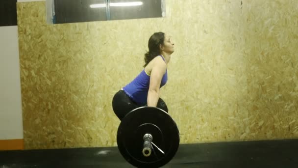 Gewichtheffen: de indrukwekkende kracht van een jonge vrouw die een zware barbell opheffen — Stockvideo