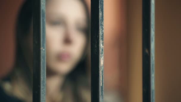 Blurred image of a young woman behind bars — Αρχείο Βίντεο