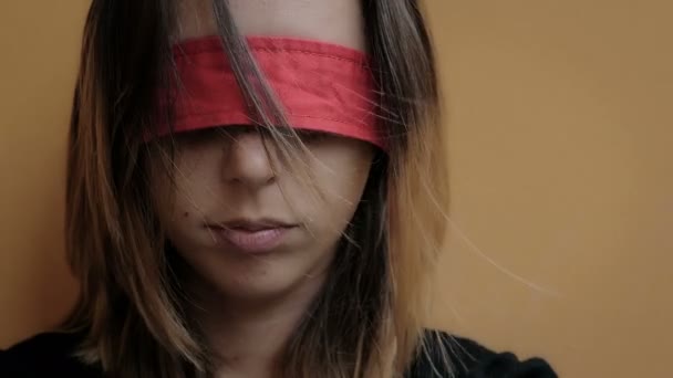 Abused woman with eyes blindfolded with red ribbon — Stockvideo