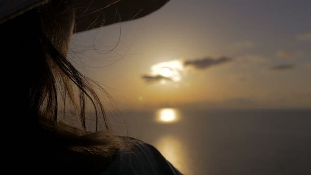 Деталі жінки, яка дивиться захід сонця над морем — стокове відео