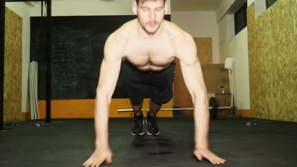 Jovem atleta crossfit sozinho no ginásio fazendo push-ups- câmera lenta — Vídeo de Stock