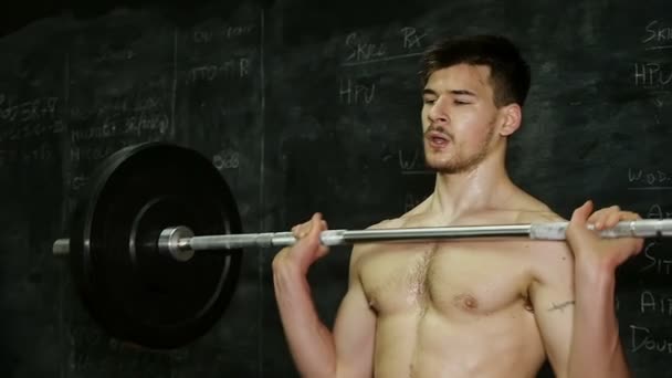 Genç adam ağırlık-Crossfit kaldırmaya odaklanmış — Stok video