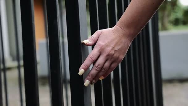 Manos de mujer caminando tocando las barras de una puerta — Vídeos de Stock