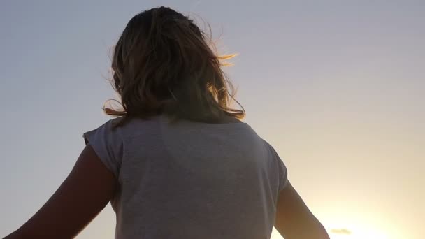 Detail of a young girl's back intently watching the sunset — ストック動画