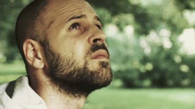  kel adam parkta yalnız gökyüzüne yağmur başlamak görmek için örnek alıyor