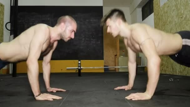 Twee cross fit atleten doen push-ups samen geven hoge vijf — Stockvideo