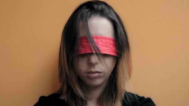 Жінка в заручнику з зав'язаними очима лежить на стіні — стокове відео