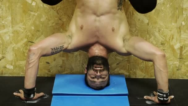 Bodybuilder treinen doen de handstand muur — Stockvideo