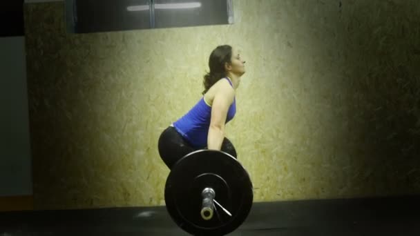 Woman athlete crossfit does the push ups with a huge barbell — Stockvideo