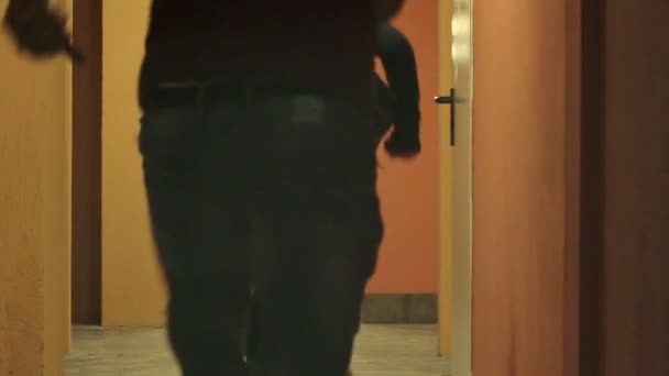 Homme et femme courent sauvagement dans un couloir parce que le bâtiment prend feu 