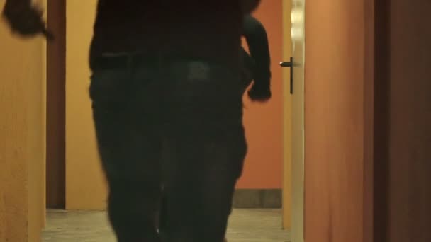 Man and woman running wildly in a corridor because the building is catching fire — Stock Video