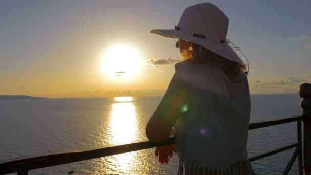 Mulher apoiada no corrimão assistindo o pôr do sol romântico sobre o mar — Vídeo de Stock
