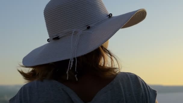 Mujer elegante espalda con sombrero mientras escanea el horizonte — Vídeo de stock