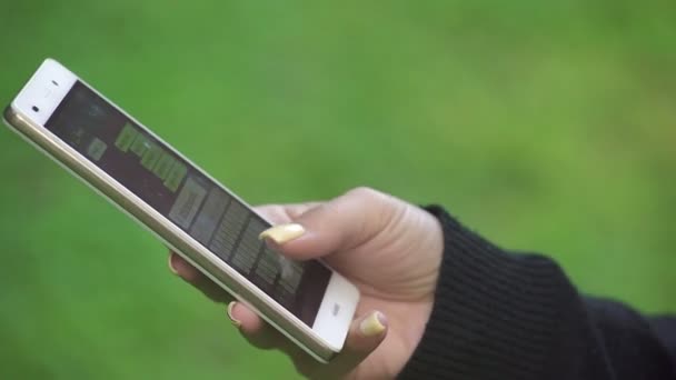 main de femme avec de longs ongles tout en écrivant un message avec votre smartphone 
