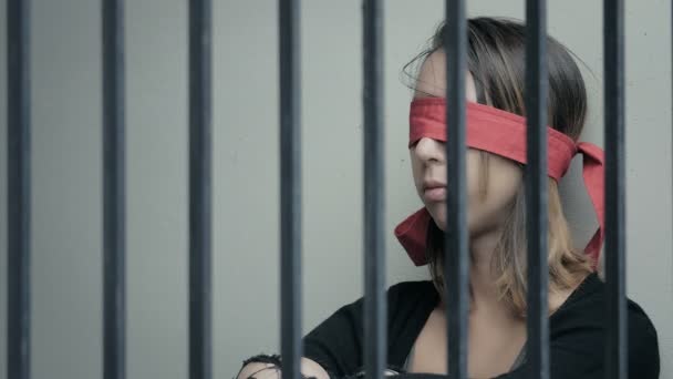 Mädchen mit verbundenen Augen hinter Gittern — Stockvideo