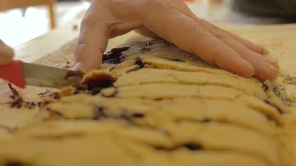 Woman hand cut into slices a homemade strudel on to a cloth — Stock Video