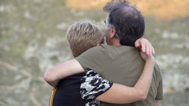 Pareja de mediana edad de pie hacia atrás mientras abraza tiernamente — Vídeo de stock