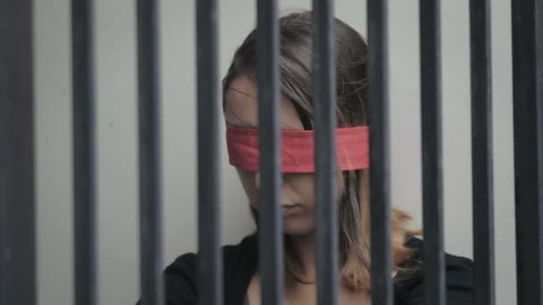 Молодая женщина похищена и заключена в камеру, с завязанными глазами — стоковое видео