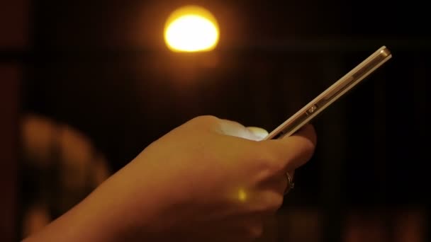 Geceleri onun akıllı telefonlar ile mesaj yazarken evli kadın eli — Stok video