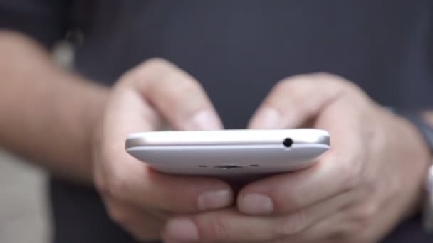 Detail of the young man's hand chatting with his smartphone — Stock Video