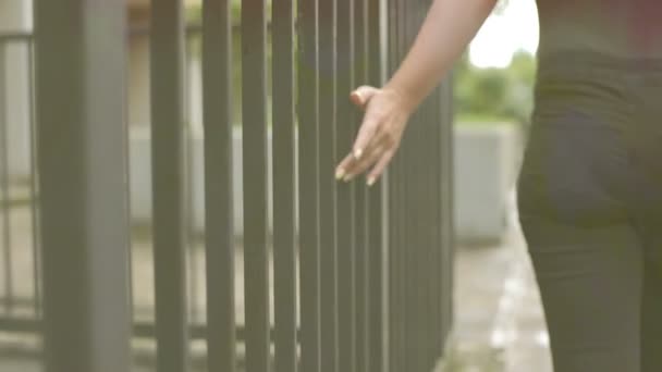 Vrouw in liefde lopen alleen in de stad strelen van de balken van een gebouw — Stockvideo
