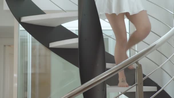 Sexy joven mujer desciende las escaleras y sonriendo a la cámara — Vídeos de Stock