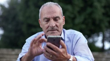 Konsantre yaşlı adam cep telefonu ile sohbet