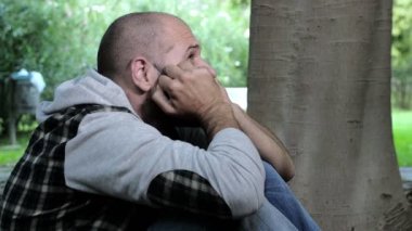 yerde oturan bir parkta umutsuz adamın