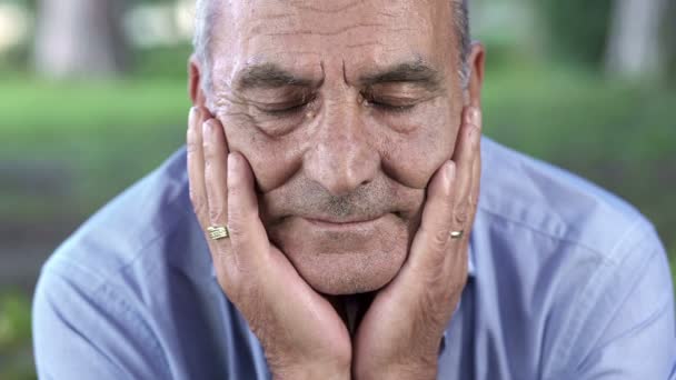 Relaxed old man holding his face with his hands — Stock video