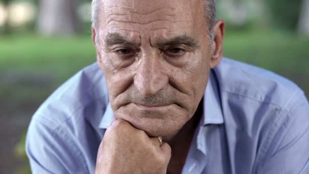 Thoughtful elderly man opens his eyes and looks at the camera — Αρχείο Βίντεο