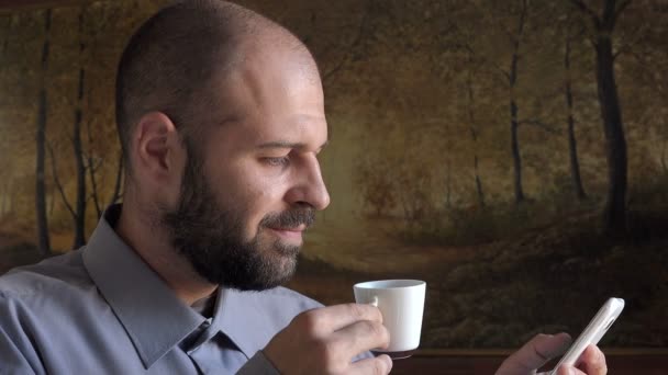 Thirty years  peaceful man does breakfast with coffee and writing sms — Stock Video