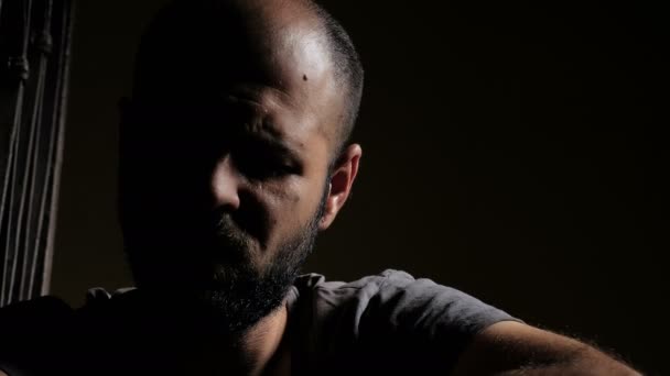Сумний і депресивний чоловік у темряві, думаючи про самогубство — стокове відео