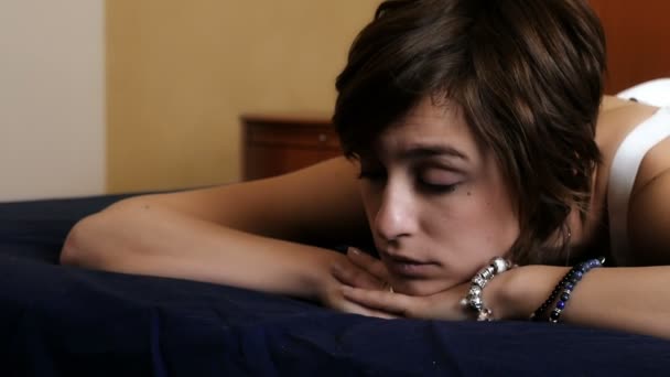 Young and sensual woman on the bed reflects on her relationship — Stock Video