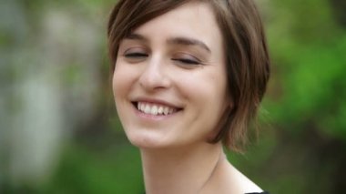 Güzel genç bayan kameraya gülümsüyor.