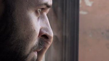 pencereye dikkat sakallı ciddi adam eğilir