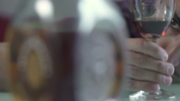 Betrunkener beobachtet sein Glas Rotwein — Stockvideo