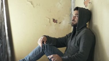 merdivenlerde oturan genç uyuşturucu satıcısı bir sigara uyuşturucu satıyor