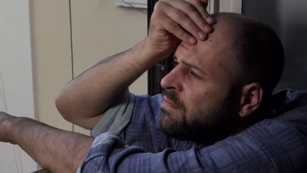 Расстроенный человек, прикасаясь лбом к окну, отражает — стоковое видео