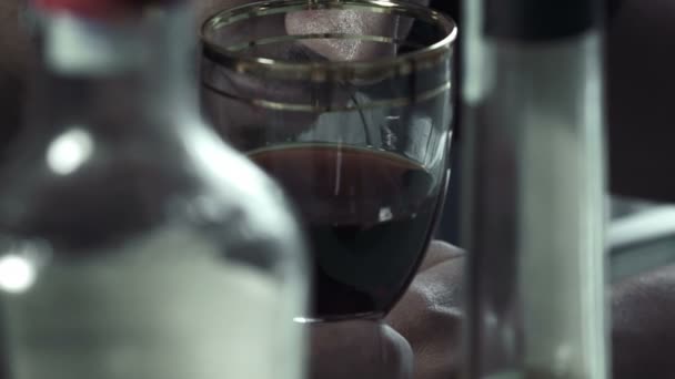 Пьяный мужчина держит в руках последний стакан — стоковое видео
