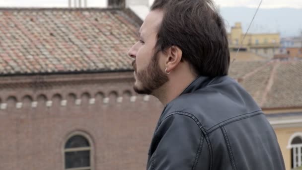 Okouzlující muž dodržuje město z terasy — Stock video