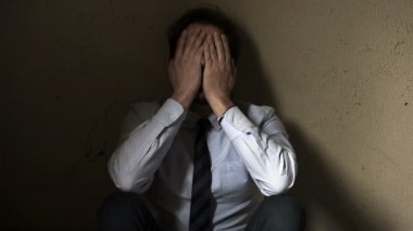 umutsuzca yüzünü elleri ile tutan işadamı