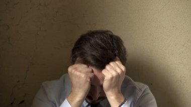 umutsuz işadamı başını elleri koyar.