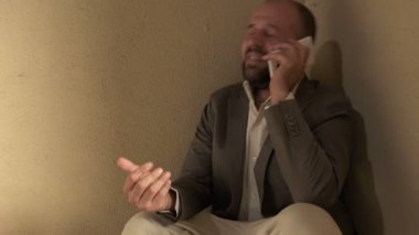 umutsuz adamın karısıyla yere çömelmiş telefonda konuşuyor