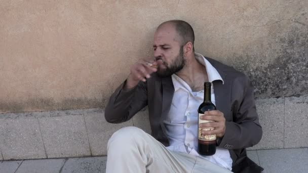 Pijany biznesmen leżące na ziemi, płacz, picia butelka wina — Wideo stockowe