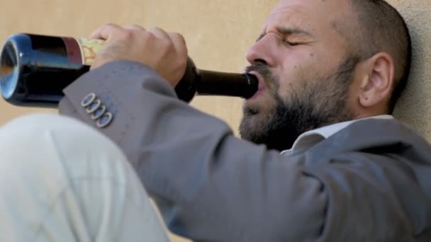 Ubriaco uomo d'affari che piange, beve una bottiglia di vino — Video Stock