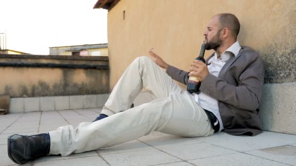 L'homme seul couché sur le sol se saoule avec une bouteille de vin — Video