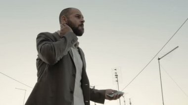 Adam sinirli bir telefon görüşmesi için beklerken yürür