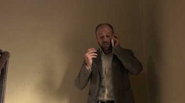  iş adamı merdivenlerden aşağı hızlı bir şekilde telefonla konuşurken geliyor