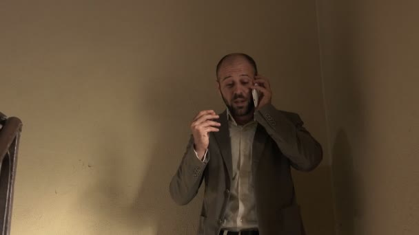 Επιχειρηματίας που έρχεται κάτω από τις σκάλες γρήγορα ενώ μιλάτε στο τηλέφωνο — Αρχείο Βίντεο